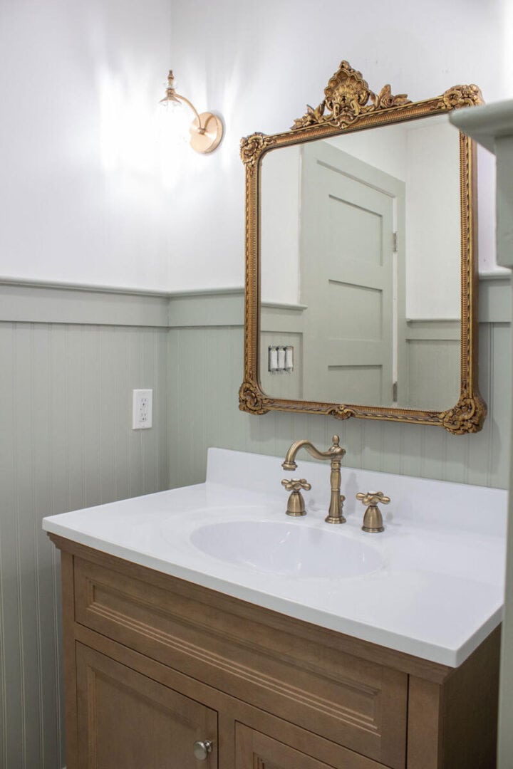 small-bathroom-with-wood-vanity-green-paint-and-beadboard