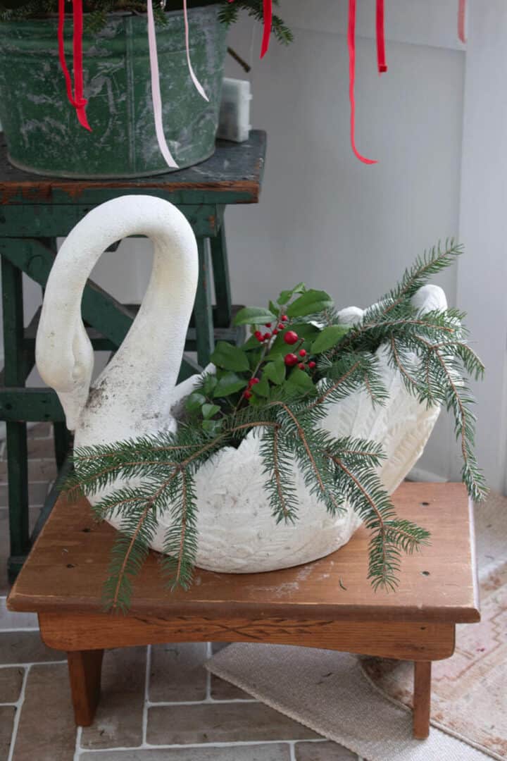 Swan-planter-for-Christmas filled with holly berry branches